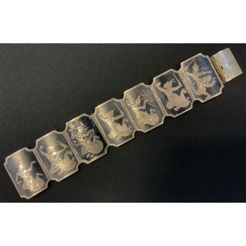 340 - A Siam silver coloured metal and black enamel seven panel bracelet, Dancing figures, compression cla... 