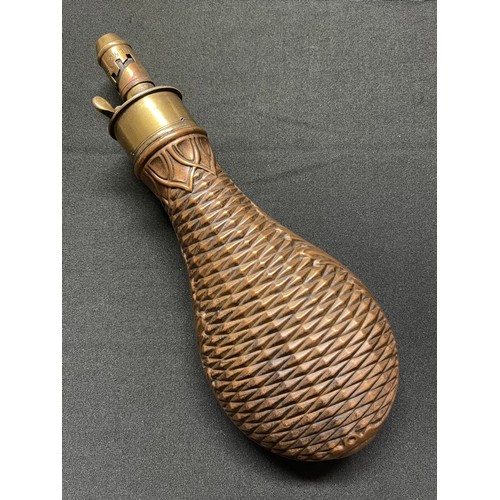 192 - A Brass and Copper Powder Flask embossed with a basket weave design. Four adjustable measures of bla... 