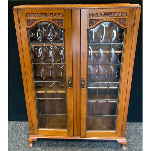 15 - An early 20th century walnut display cabinet, the two doors with slightly bowed astragal glazed door... 