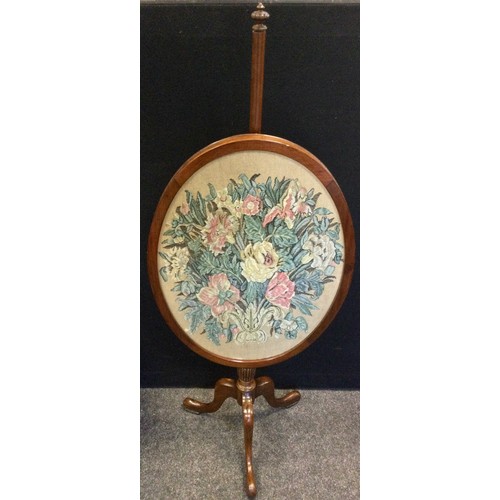 69 - A late Victorian mahogany pole screen, the glazed oval screen with an embroidered floral panel, trip... 