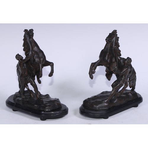 5231 - After Guillaume Coustou The Elder, a pair of dark patinated  Horse Tamer of Marly-le-Roi, ebonised b... 