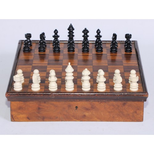 5245 - An Art Deco period walnut and parquetry games box, the hinged cover inlaid for chess, enclosing a fi... 