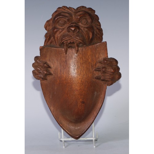 5154 - A North European mahogany boss, carved as a lion supporting a shield, 26cm x 17.5cm