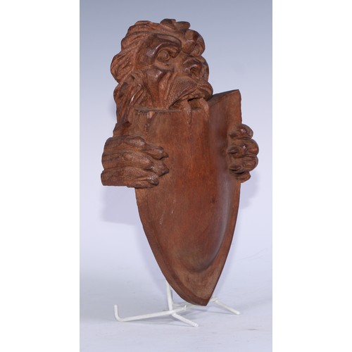 5154 - A North European mahogany boss, carved as a lion supporting a shield, 26cm x 17.5cm