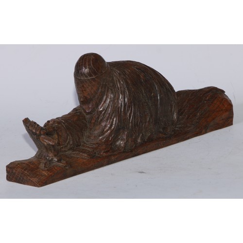 5094 - A Continental oak carving, of a veiled widow or vestal, kneeling at a stone, 35.5cm long