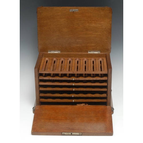 5132 - A late 19th century oak fall front humidor cigar cabinet, the hinged cover with pressed panel depict... 