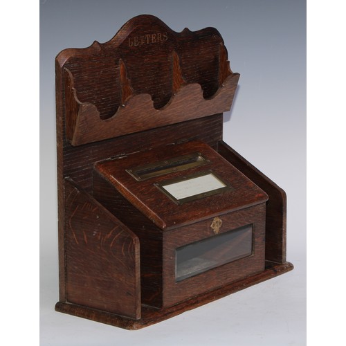 5134 - A late Victorian oak country house letter box, shaped cresting above four pigeon holes and a hinged ... 