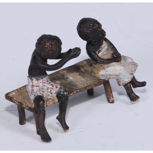 5172 - A pair of Austrian cold painted bronzes, of a young black boy and his reluctant sweetheart, seated o... 