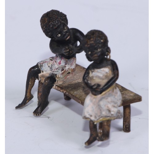 5172 - A pair of Austrian cold painted bronzes, of a young black boy and his reluctant sweetheart, seated o... 