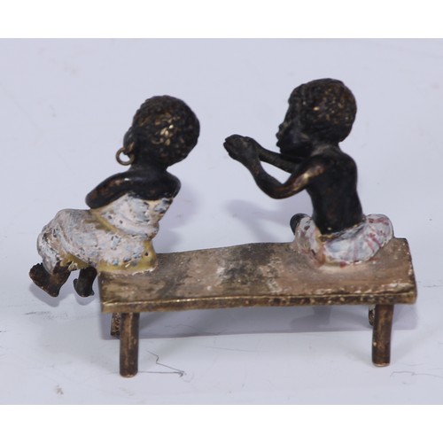 5172 - A pair of Austrian cold painted bronzes, of a young black boy and his reluctant sweetheart, seated o... 