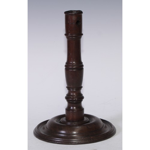 5409 - Treen - a re-purposed mahogany candlestick, turned pillar and base, 27cm high, the timber c.1820