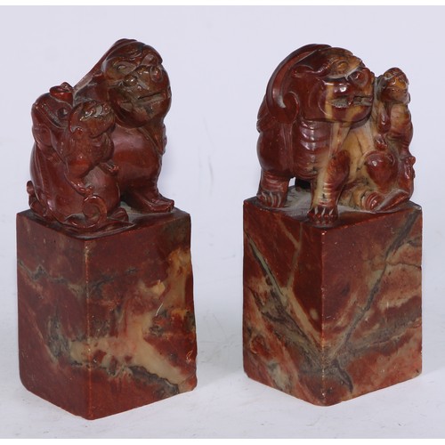 5177 - A pair of Chinese soapstone desk seals, each carved with a temple lion, 13.5cm high