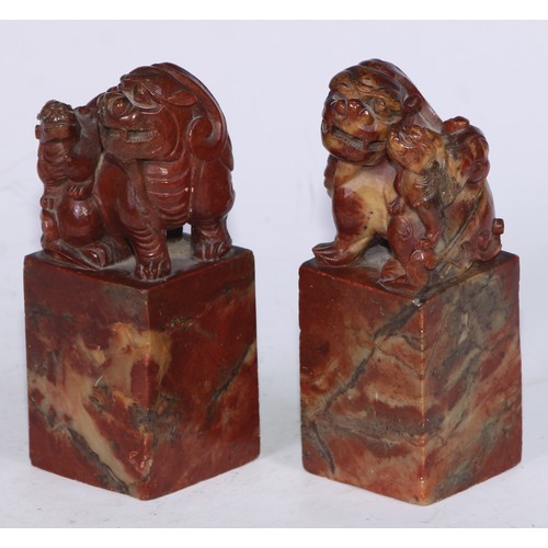 5177 - A pair of Chinese soapstone desk seals, each carved with a temple lion, 13.5cm high