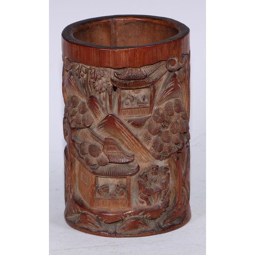 5067 - A Chinese bamboo bitong brush pot, carved in relief with figures and pagodas in a monumental landsca... 