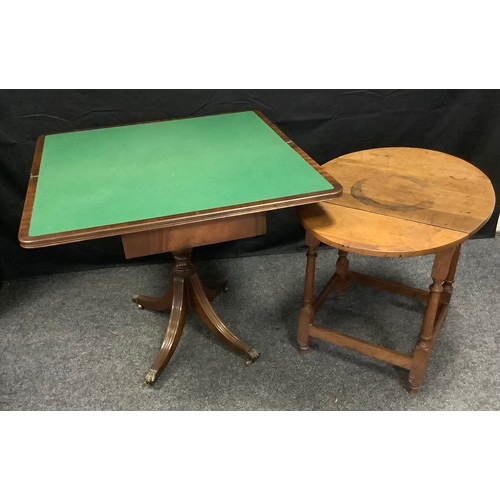 41 - A Reprodux mahogany card table, rounded rectangular top, lined playing surface, turned column, splay... 