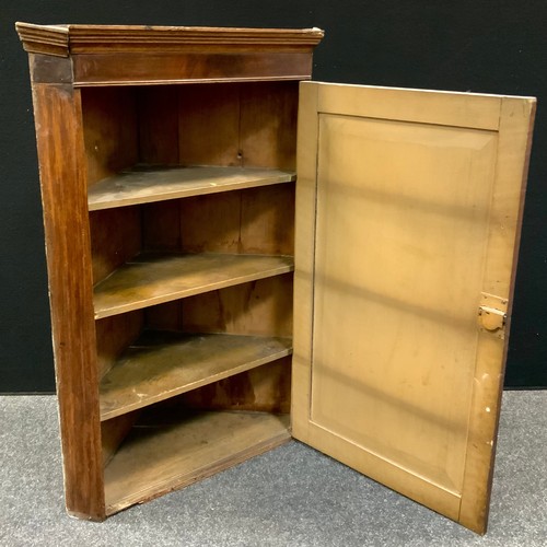 102 - A George III oak corner cupboard, moulded cornice, the field panelled door inlaid with mahogany loze... 