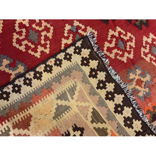 111 - A Qashgai Kilim woolen rug, the large central field woven with diagonal bands of stylized geometric ... 