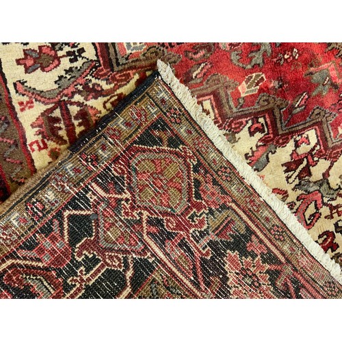 305 - A fine hand-knotted Heriz woollen carpet, woven in muted tones of red, brown and cream, 330cm x 245c... 