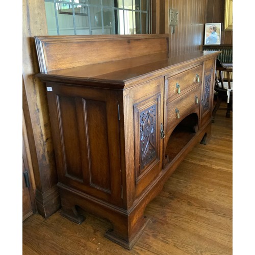 68 - An Edwardian oak sideboard, fitted with two drawers, and two panelled doors, carved with scrolls, 11... 