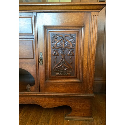 68 - An Edwardian oak sideboard, fitted with two drawers, and two panelled doors, carved with scrolls, 11... 