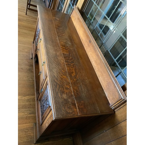 68 - An Edwardian oak sideboard, fitted with two drawers, and two panelled doors, carved with scrolls, 11... 