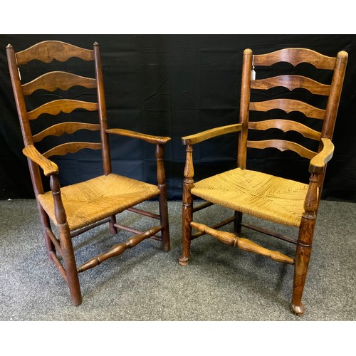 150 - An early 19th century oak ladder back farmhouse kitchen chair, outswept arms, woven rush seat, turne... 