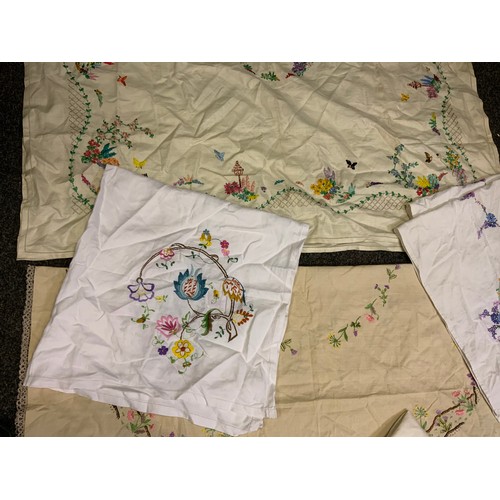 213 - Hand embroidered linen table cloths, including crinoline lady, English country flowers, etc