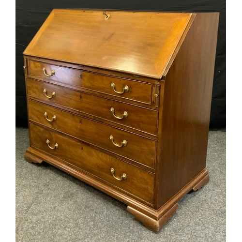 179 - An early 19th century mahogany bureau, the fall-door top enclosing a small cupboard door, flanked by... 