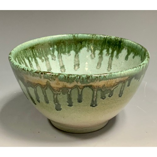 91 - A Dame Lucie Rie style studio pottery bowl, dripped in green on a light jade ground, 7cm deep, 12cm ... 