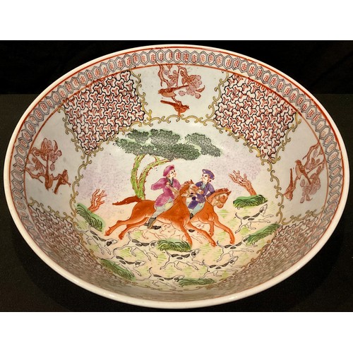 63 - A Chinese porcelain punch bowl, enamelled with hunting scenes in the manner of 18th century Chinese ... 