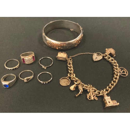 393 - A silver coloured metal charm bracelet, eight charms, padlock clasps, mostly unmarked, 48g;  silver ... 