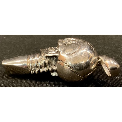 225 - A silver novelty whistle, as a skull, emerald eyes, 4.5cm long