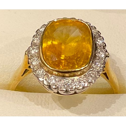 429 - An 18ct gold yellow sapphire and diamond ring, the central cusion cut stone surrounded by sixteen il... 