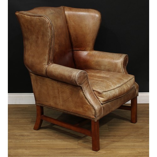 4 - A George III style reception wingback armchair, stuffed-over upholstery with studded border, squab c... 