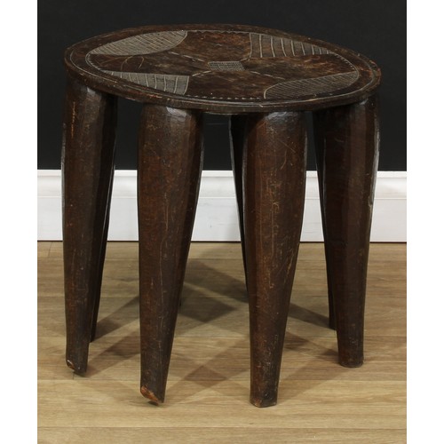 112 - Tribal Art - a Nigerian Nupe stool, the top incise carved with cowrie shells and geometric motifs, e... 