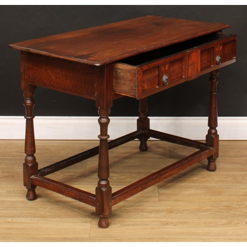 213 - An oak side table, slightly oversailing top above a long frieze drawer, the front inlaid in the Art ... 