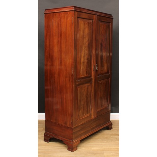 220 - A George III Revival mahogany wardrobe, moulded cornice above a pair of doors set with raised and fi... 