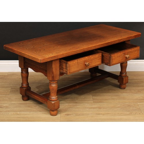 533 - An oak coffee table, rounded rectangular top above a pair of frieze drawers, turned supports, rectan... 