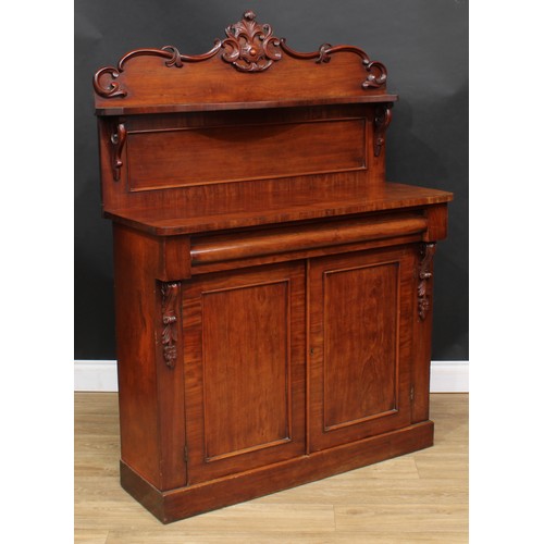 114 - A Victorian mahogany chiffonier, shaped back with serpentine shelf carved and applied with C-scrolls... 