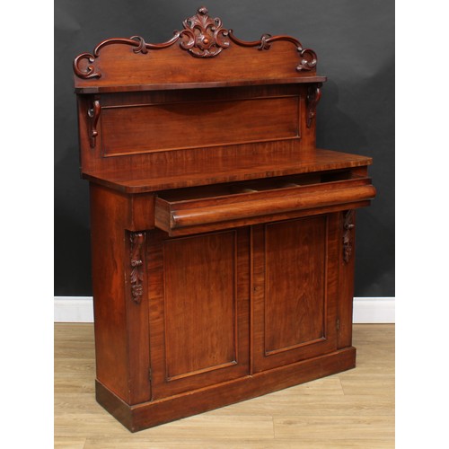 114 - A Victorian mahogany chiffonier, shaped back with serpentine shelf carved and applied with C-scrolls... 