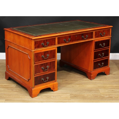 218 - A George III style yew twin pedestal desk, inset tooled and gilt writing surface above three cockbea... 