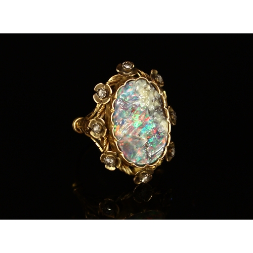 326 - A Victorian rough cut opal and diamond ring, the large shaped oval stone set within eight stylised f... 