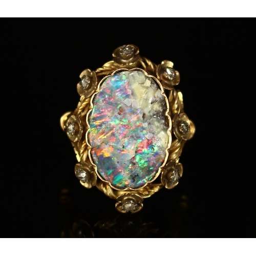 326 - A Victorian rough cut opal and diamond ring, the large shaped oval stone set within eight stylised f... 