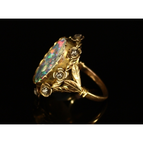 326 - A Victorian rough cut opal and diamond ring, the large shaped oval stone set within eight stylised f... 