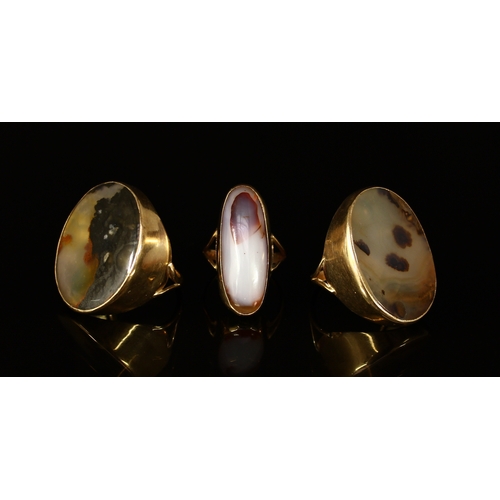 340 - An oval moss agate and 9ct gold ring, set in a deep plain collar, shank divided at the shoulder, siz... 