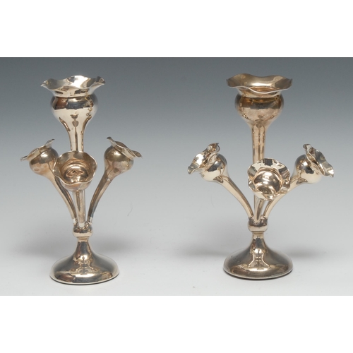 134 - A pair of Edwardian silver table centre epergnes, each with central wavy trumpet flute above three s... 