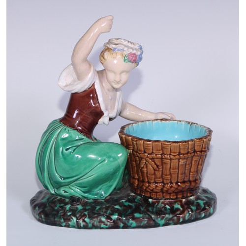 378 - A Minton majolica figure, of a lady kneeling by a basket, her arm raised, in colours, 22cm high, imp... 