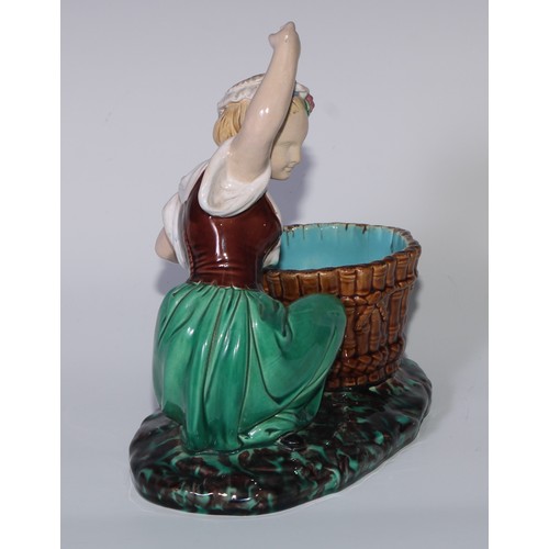 378 - A Minton majolica figure, of a lady kneeling by a basket, her arm raised, in colours, 22cm high, imp... 