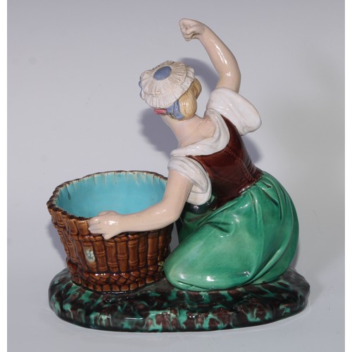 378 - A Minton majolica figure, of a lady kneeling by a basket, her arm raised, in colours, 22cm high, imp... 