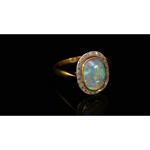 311 - A gold and opal ring, the unmarked shank probably 18ct gold, the central polished oval opal cabochon... 